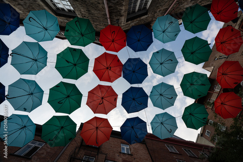 Canvas Print Colorful umbrellas hang over a street in a city during a sunny day