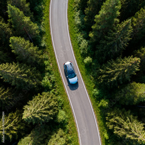 Aerial Electric Vehicle Driving Through Dense Green Forest
