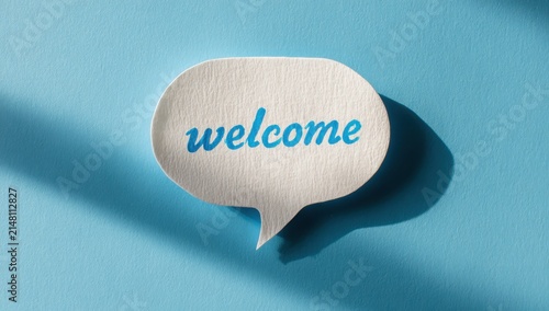 Welcome speech bubble cutout on a textured blue background with background greeting communication dialogue conversation minimalist customer hospitality invitation friendly business