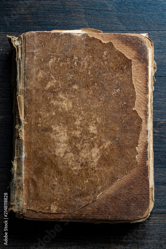 Obraz na płótnie Vintage worn book cover on dark wood, closeup