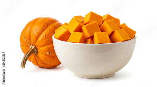 Fresh pumpkin and a bowl of cubed pumpkin isolated on white background