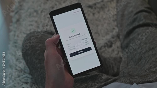 Man Relaxing at Home and Placing Online Sports Bet on Mobile Phone, Successful Wagering Confirmation Screen