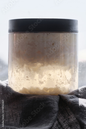 Kefir starter in a jar near the window. Selective focus