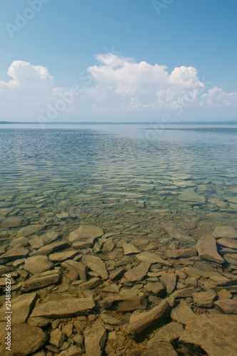 Rocky shoreline of lake Uvildy in summer with its clear water, South Urals, Russian Federation
