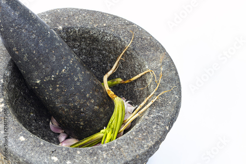 Foto Traditional heavy granite stone mortar and pestle filled with fresh garlic clove