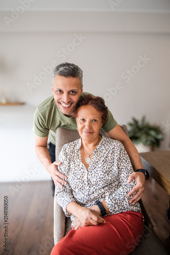 Close Portrait of Man Embracing Senior Woman at Home