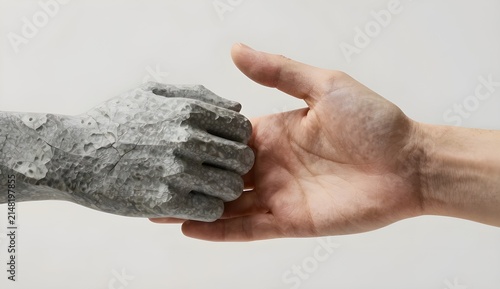 Human hand offering help to a cracked stone statuesque hand