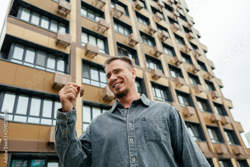 Homeowner hold house key outside apartment building