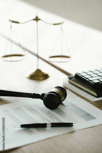 Judge's gavel beside a contract document and scales of justice on a desk, symbolizing legal agreements, law, justice, courtroom decisions, and legal services.