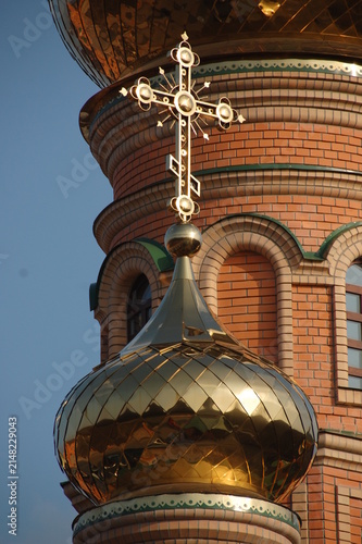 Canvastavla Close-up of a golden onion dome topped with an ornate Orthodox Christian cross on a red brick church tower