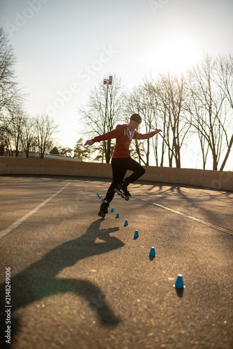 Obraz na płótnie Young man practicing freestyle rollerblading tricks
