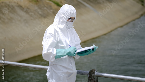 Fotografie Environmental Inspector Completing Water Quality Inspection Report Beside Canal