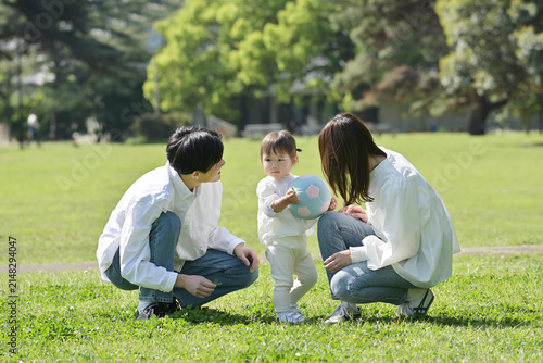 芝生の上でくつろぐ若いファミリー