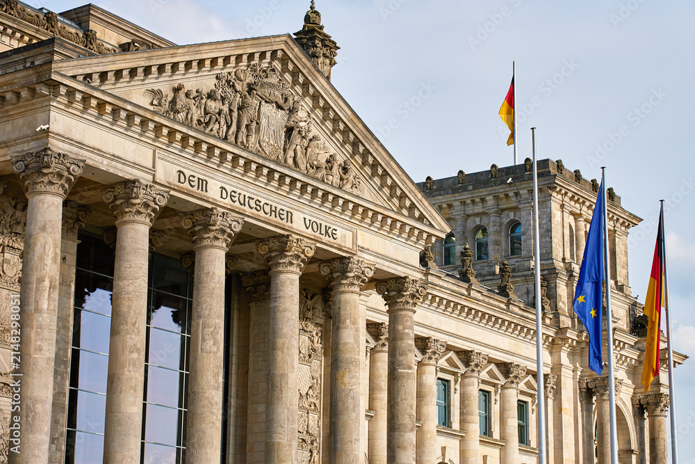 Fototapeta premium Reichstag building with German and European Union flags in Berlin