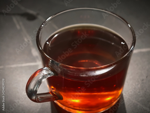transparent glass cup of hot black tea