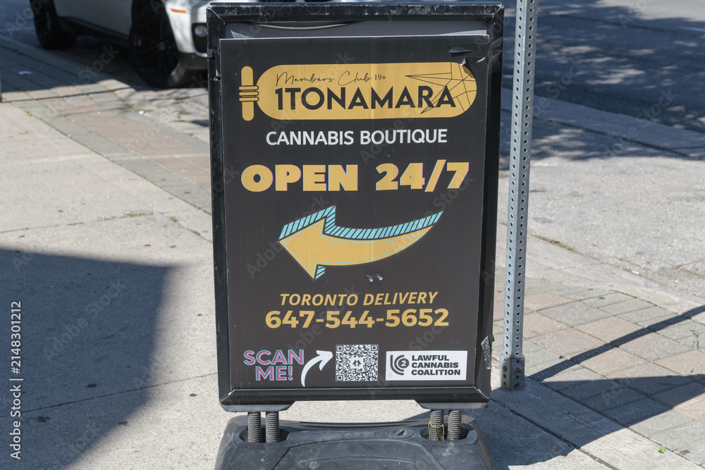 Fototapeta premium sidewalk sign outside 1Tonamara, a cannabis store, located at 202 Spadina Av, Toronto