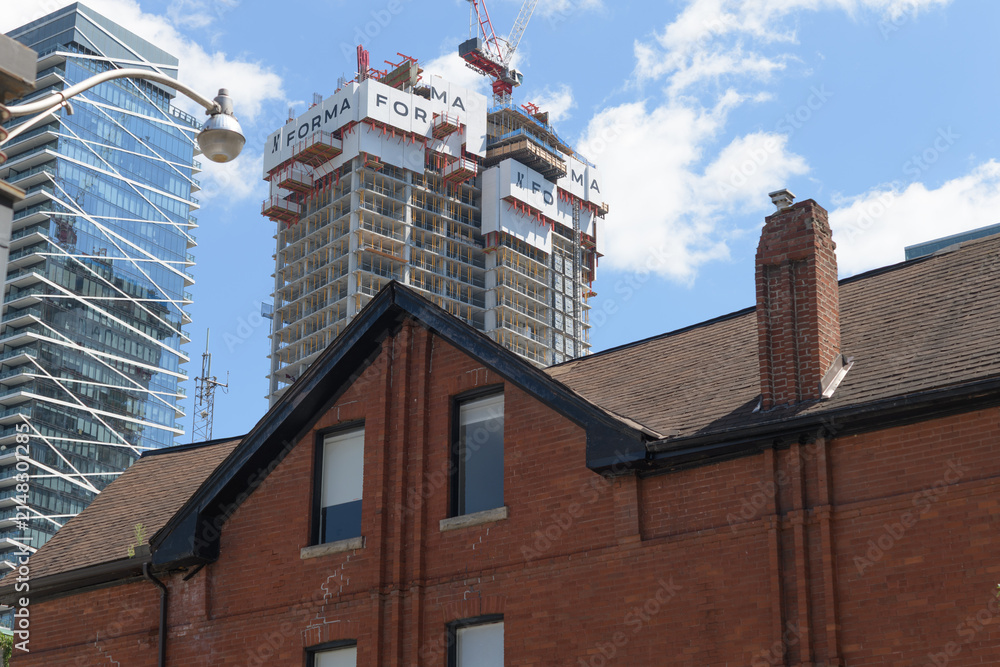 Fototapeta premium Theatre Park apartment building and FORMA Toronto Condos (Mirvish + Gehry) under construction contrasted with old building on John St