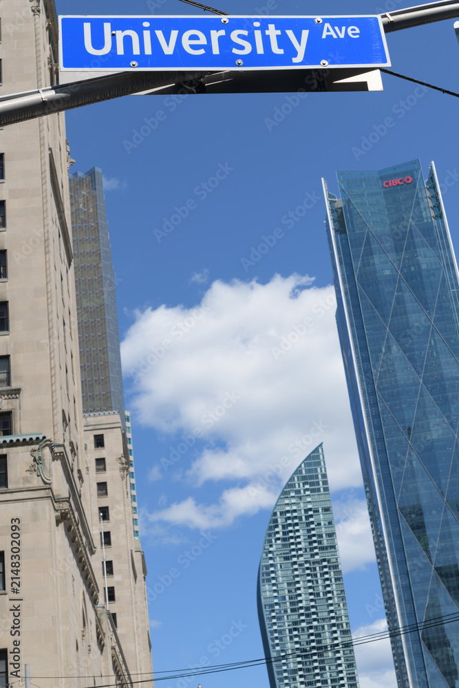 Fototapeta premium street sign at University Av where it intersects at Front St W with view looking east to Royal York hotel, L-Tower condo, and CIBC Square north towers, Toronto