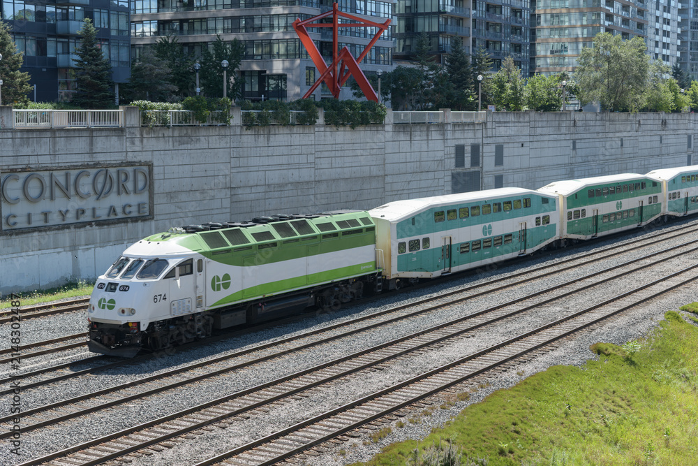 Fototapeta premium Go Trains arriving east bound on the Union Station Rail Corridor at Concord Cityplace (Spadina Av overpass), Toronto