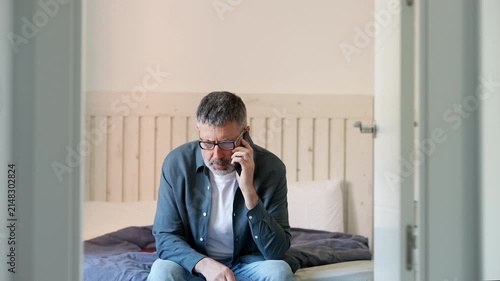 Mature man receiving bad news on the phone and crying