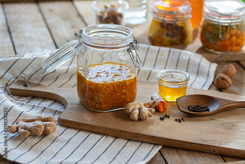 Fotografie Probiotic healthy ferment with the ingredients ginger, turmeric, and honey - a h