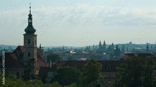 Historic Prague city skyline features iconic spires and towers in daylight. Traditional Czech architecture forms a famous European panorama. Cultural landmark represents travel heritage.