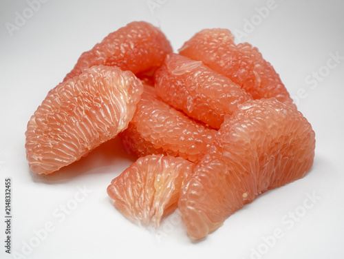 Freshly prepped organic pink pomelo citrus segments isolated on a clean white backdrop