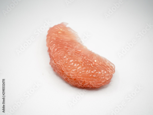 Macro studio shot of peeled red citrus maxima pulp vesicles displaying juicy transparent texture