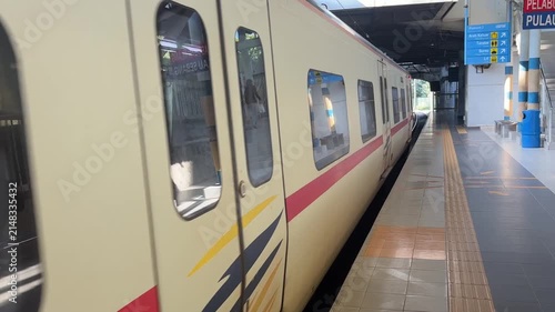 Malaysian KTM Komuter electric train arriving at the station platform, public transportation.