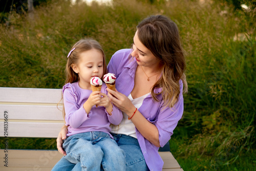 mom and child eating ice cream outside in summer, little child and mother having fun together, walking in the park with ice cream, summer vacation