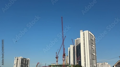 Close up of a massive industrial crawler crane operating at a bridge construction project.