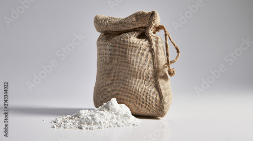 Burlap sack of diatomaceous earth with spilled powder on sweep, ecommerce banner concept