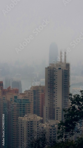 A foggy cityscape view with skyscrapers blending into the misty atmosphere in downtown Hong Kong