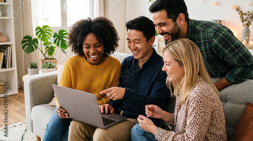 Diverse group of friends laughing together while watching a laptop screen on a couch at home