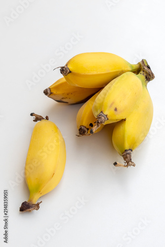 a bunch of small yellow bananas on a white background