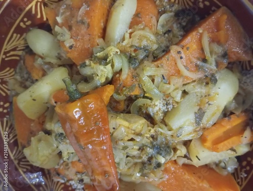 Traditional Moroccan couscous with steamed vegetables and tender meat in authentic clay dish