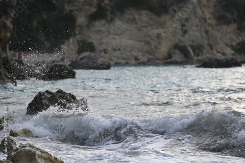 Canvas Print Churning ocean water and white sea foam washing over coastal rocks on rocky shor