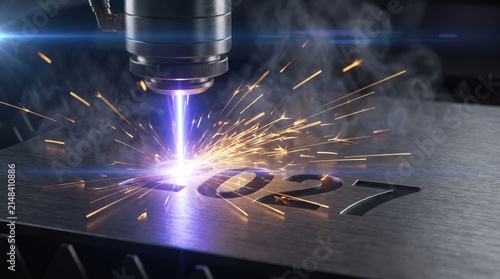 Laser machine engraves the year 2027 onto a dark metallic surface with sparks.
