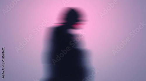 ピンクの背景に浮かぶ黒い人物のシルエット