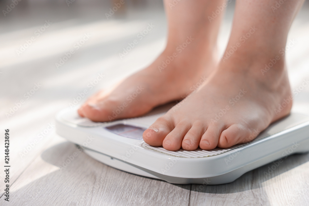 Fototapeta premium Overweight woman on scale at home, closeup. Space for text