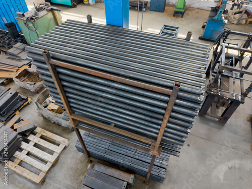 Obraz na płótnie Assorted steel profiles, hollow structural sections, metal pipes, and bars organized on industrial storage racks in a workshop