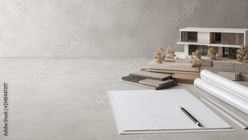 Minimalist workspace with architectural model and design materials on a neutral background