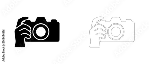 Hand holding photo camera vector icon filled and outline, taking photo and photography hobby symbol.