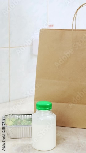 Woman pack ready meal lunch for clients. Delivery of balanced diet food. Chef collect healthy daily menu boxes in plastic takeaway containers. Woman cook on white kitchen. Restaurant business concept