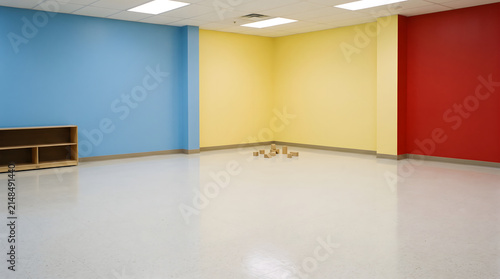 Empty Colorful Room with Wooden Shelf and Scattered Blocks