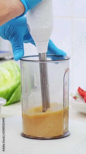 Cook woman in restaurant kitchen make homemade sweet and sour sauce for olive oil salad dressing. Professional chef mix ingredients in blender bowl. Healthy and diet food delivery concept. 4K footage
