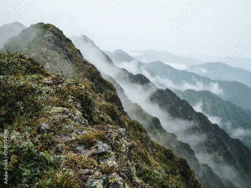 High angle view of a vegetated mountain range with low lying cloud below