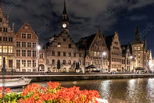 Illuminated Historic Buildings and Canal View with Flowers at Night in Ghent, Belgium