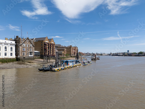 London, United Kingdom - 06 July 2026: Aerial view of the Metropolitan Police Marine Policing Unit on the River Thames, with police boats docked by historic brick buildings under a blue sky.
