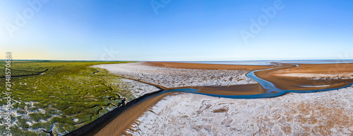 Foto Aerial view captures coastal salt flats and winding river